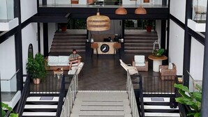 Un edificio moderno con una escalera central, varios niveles y lámparas colgantes.