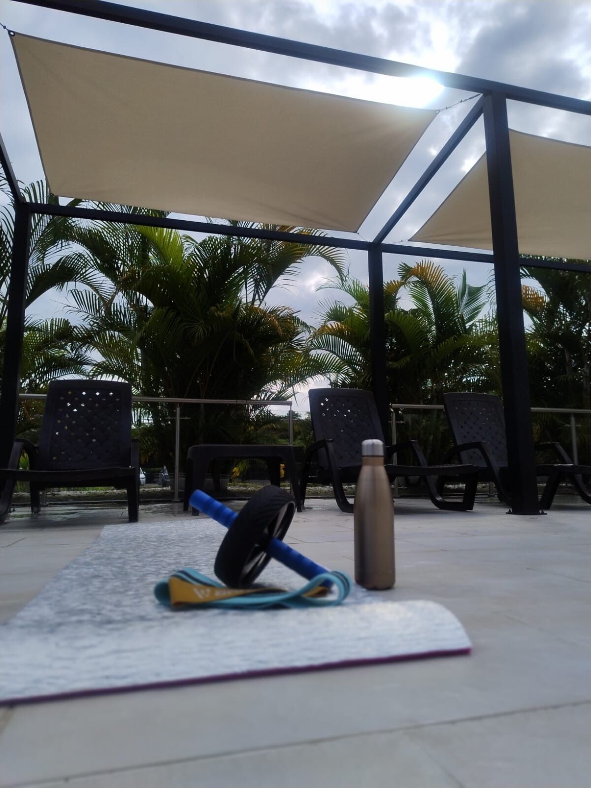 An outdoor seating area with a table, chairs, and exercise equipment.