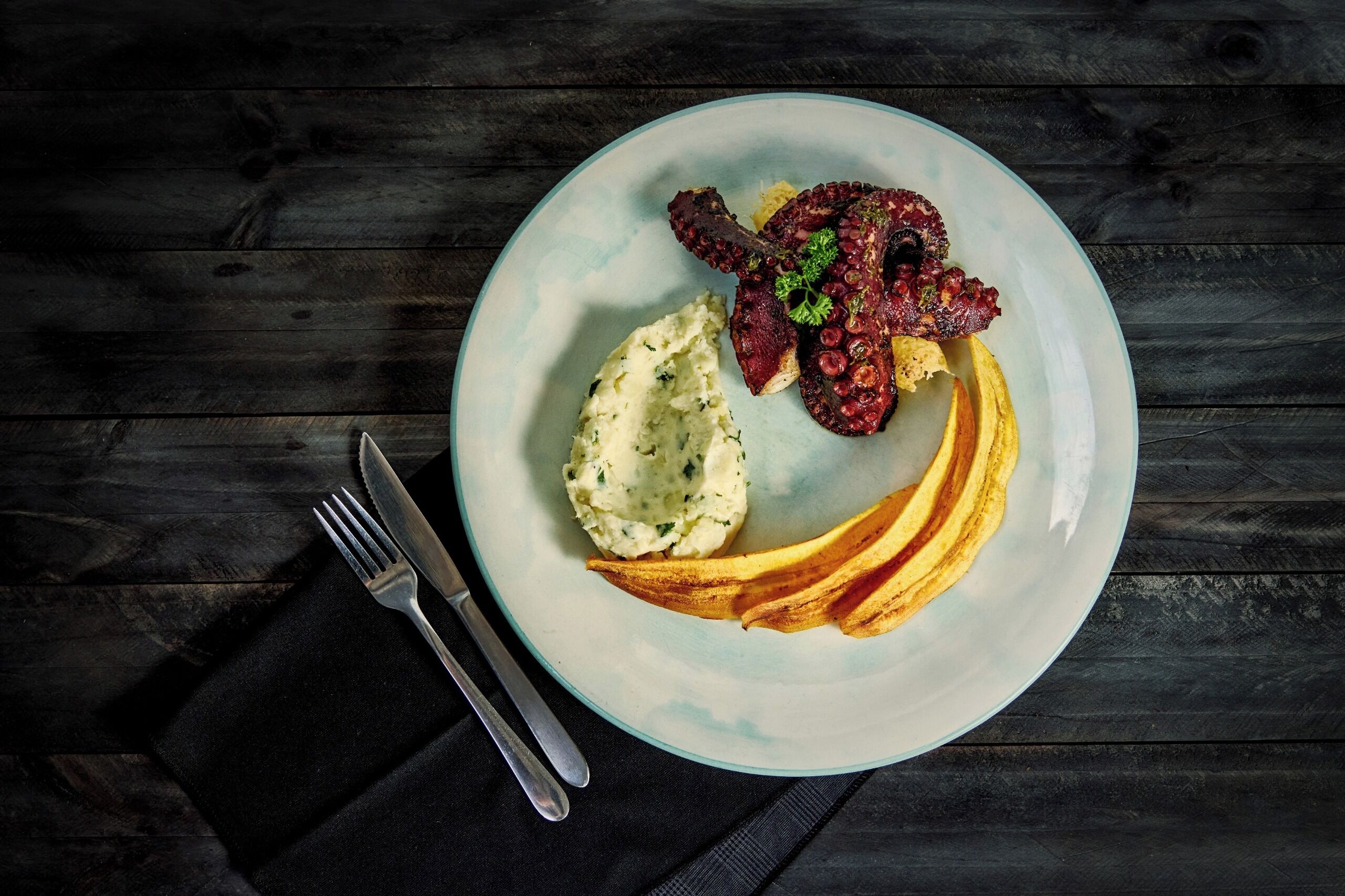 A plate with food on a dark wooden table.