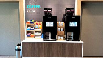 Una estación de café con dos máquinas de espresso, una exhibición de productos de café y un letrero que dice 'MUST HAVE COFFEE'.