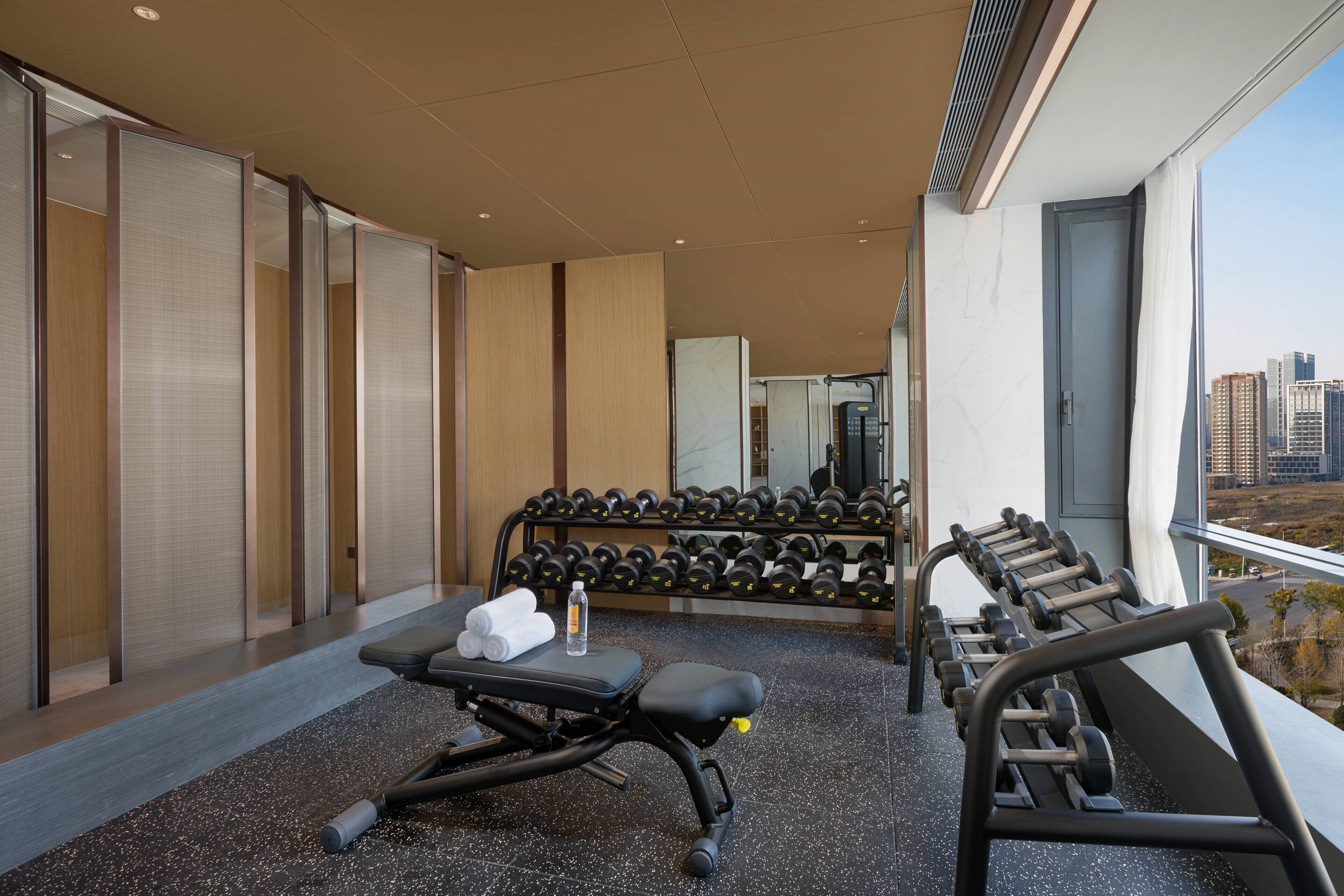 A gym with exercise equipment, towels, and a water bottle.