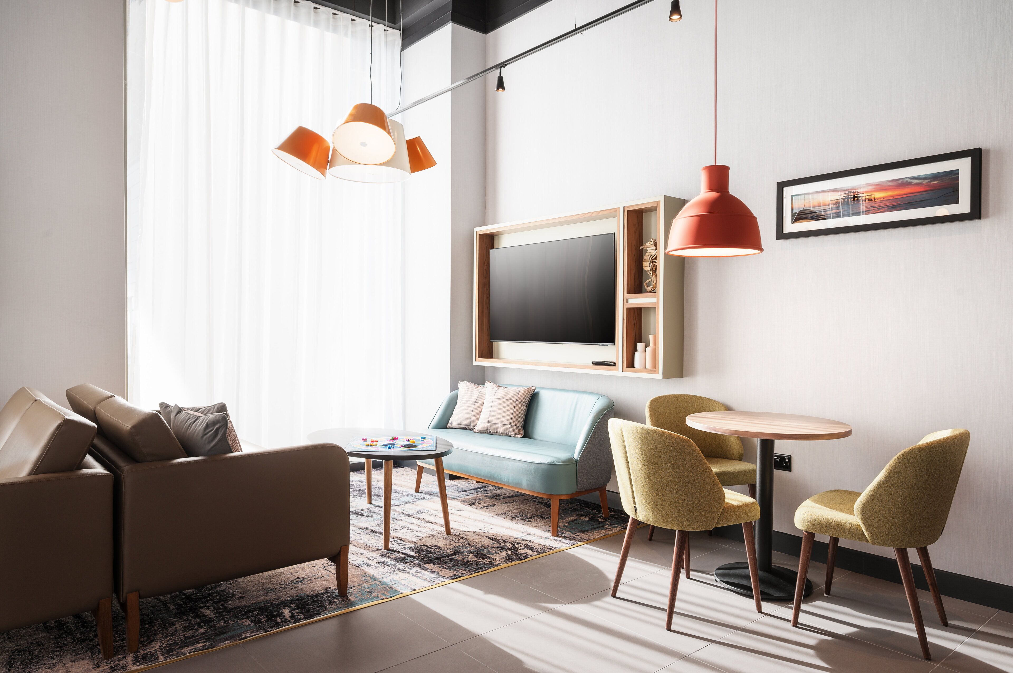 A modern living room with a sofa, chairs, a coffee table, and a TV.