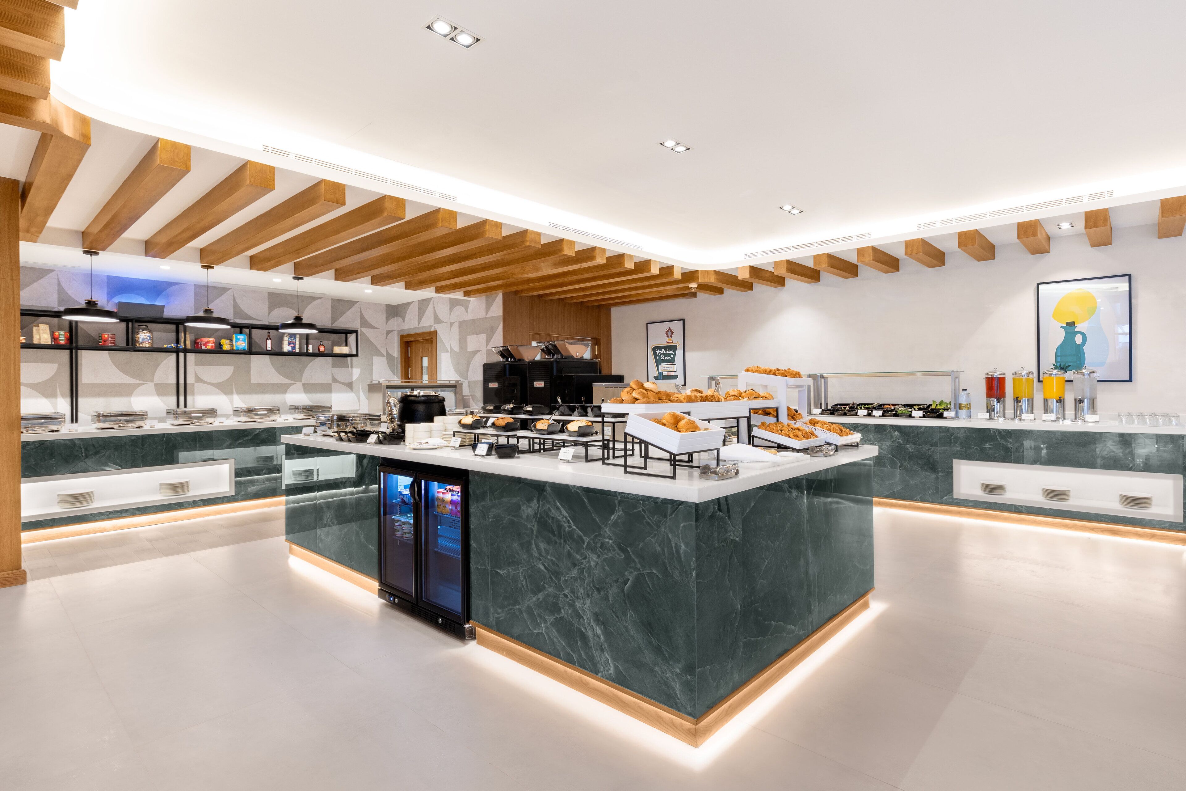 A modern breakfast bar with marble countertops, wooden beams, and a digital display.