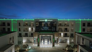 A Holiday Inn hotel with a modern facade, illuminated signage, and a central entrance. - Holiday Inn Riyadh the Business District by IHG (Riyadh)