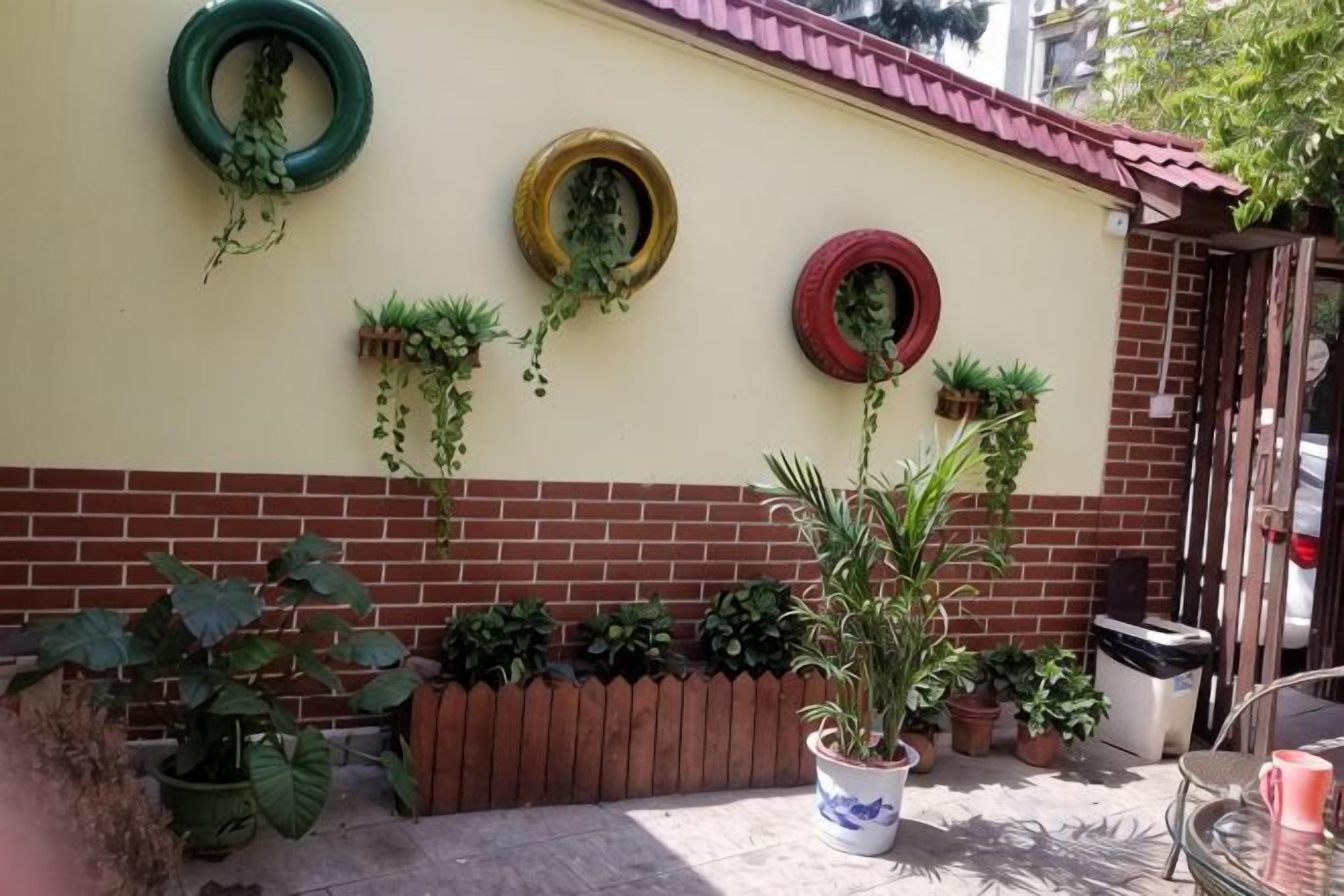 A wall with potted plants and hanging greenery.