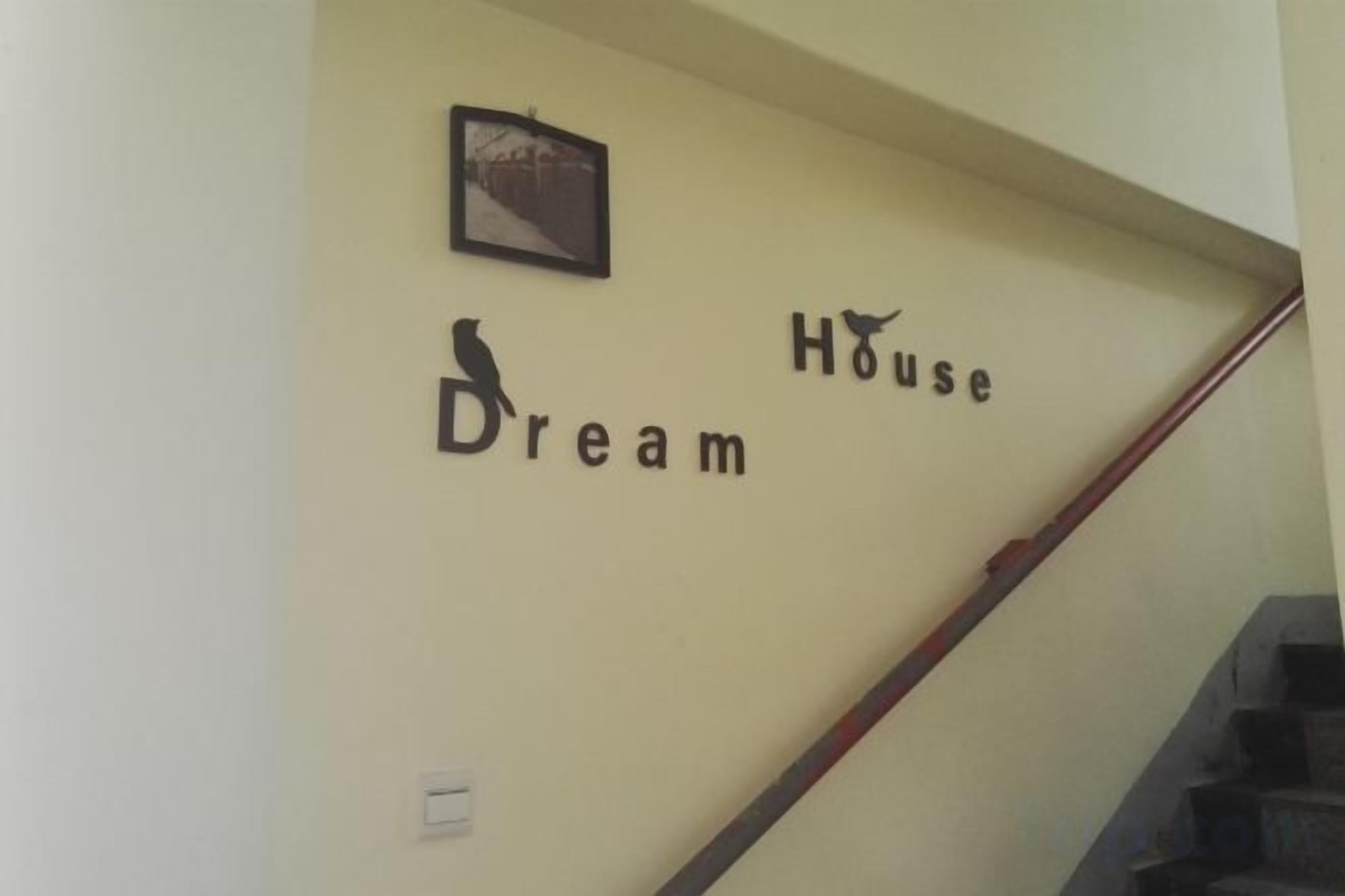 A staircase with a wall sign that reads 'Dream House.'
