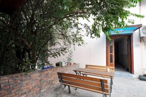 A courtyard with a wooden bench, a brick wall, and a tree. - Huxiangyi Internationa Youth Hostel Changsha Yuelushan (Changsha)