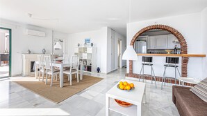 Una sala de estar moderna con comedor, cocina y chimenea.