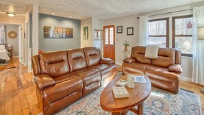 A living room with two brown leather sofas, a wooden coffee table, and a patterned rug. - High-Speed WiFi, Pool Table, private HOT TUB, Fire Pit, Game Room, 2 Kitchens! (Maggie Valley)
