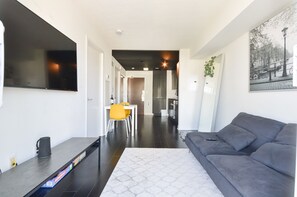 Relax in a stylish living space with a sofa, flat-screen TV, and dining area.