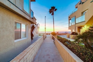 Stroll along the paved pathway, surrounded by modern buildings with balconies and scenic views.