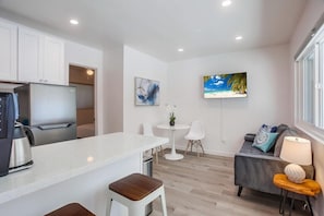Enjoy a comfortable stay in this apartment with a spacious kitchen, sofa, and flat-screen TV.