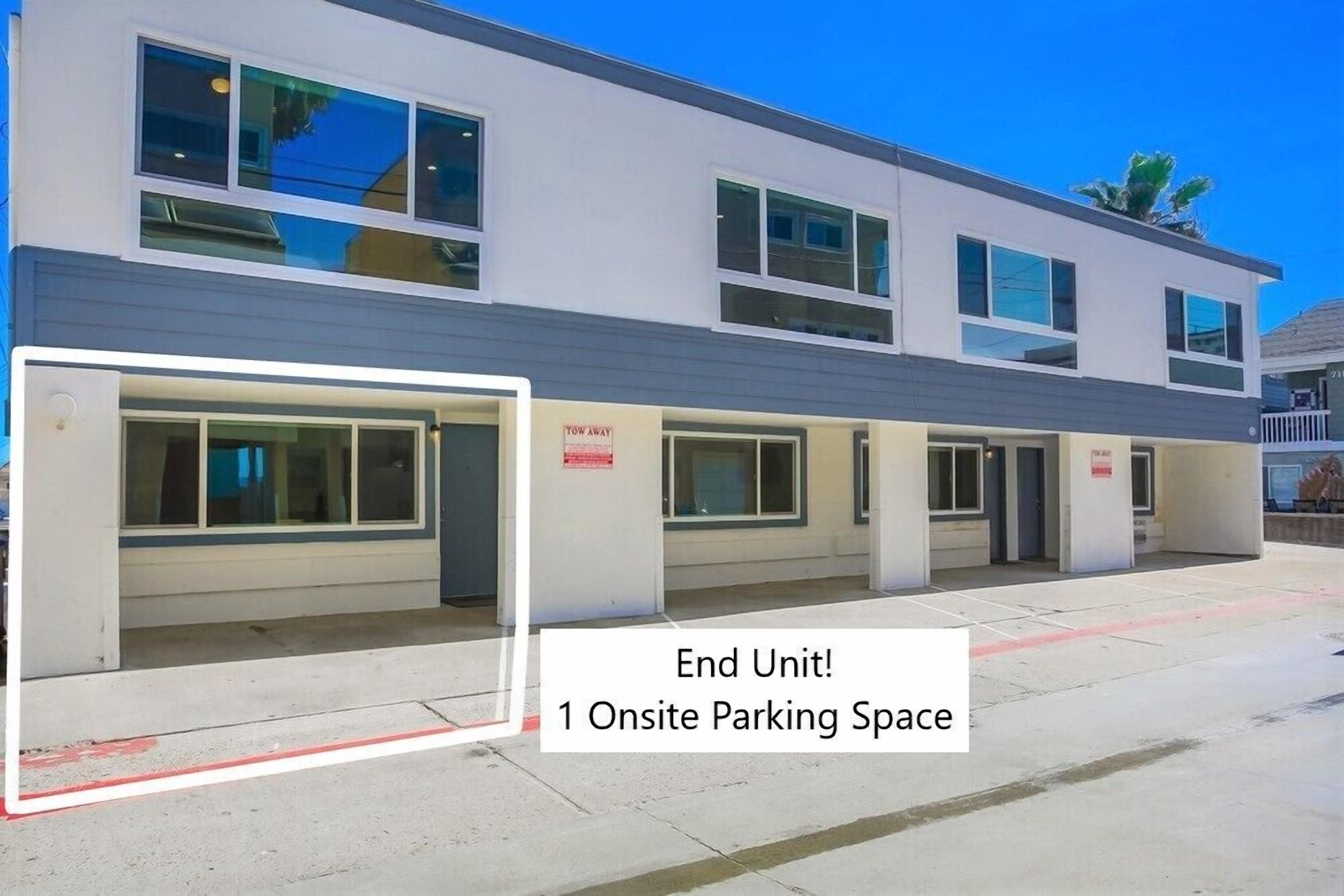 A modern building with a parking area labeled "End Unit! 1 Onsite Parking Space."