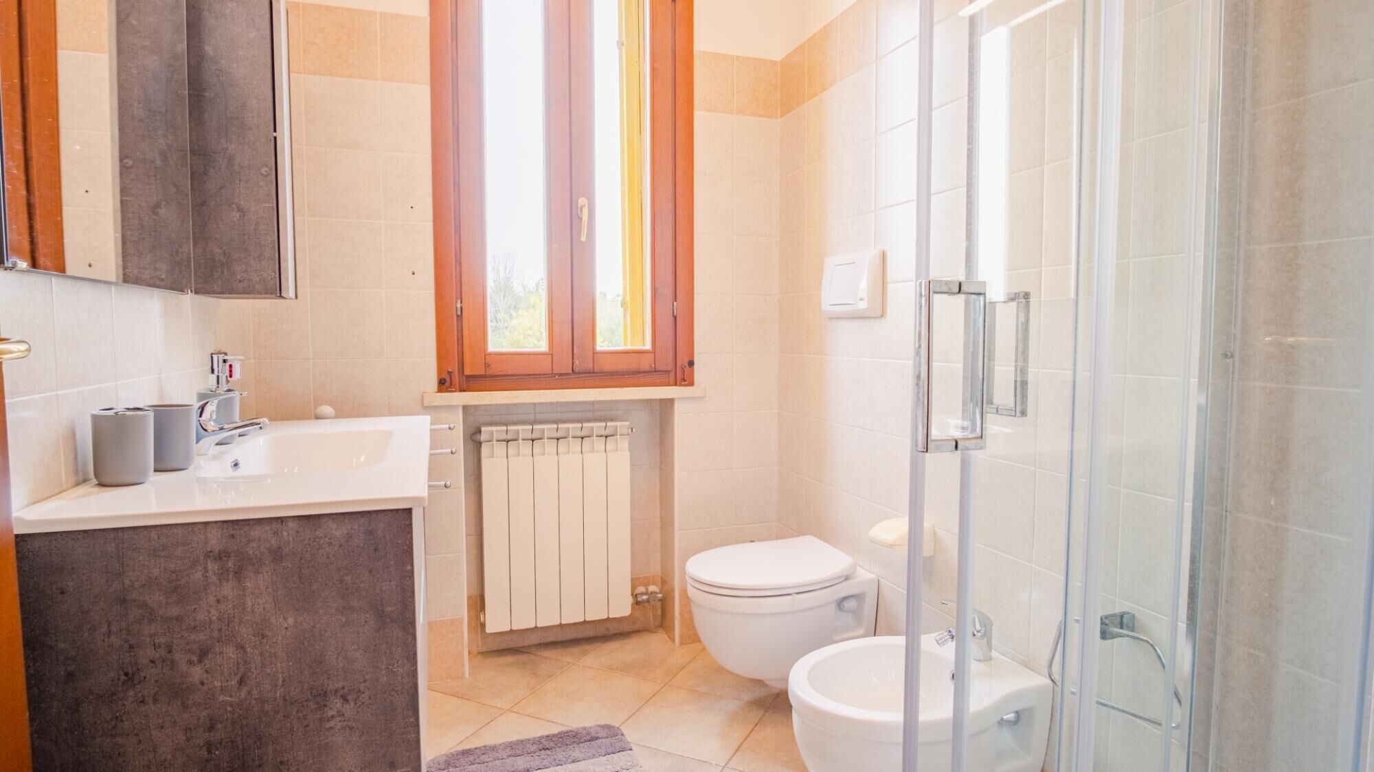 Une salle de bain avec douche, toilettes et lavabo.