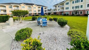 A courtyard with outdoor seating, surrounded by multi-story buildings with balconies. - First floor gorgeous condo in Myrtle Beach (Myrtle Beach)