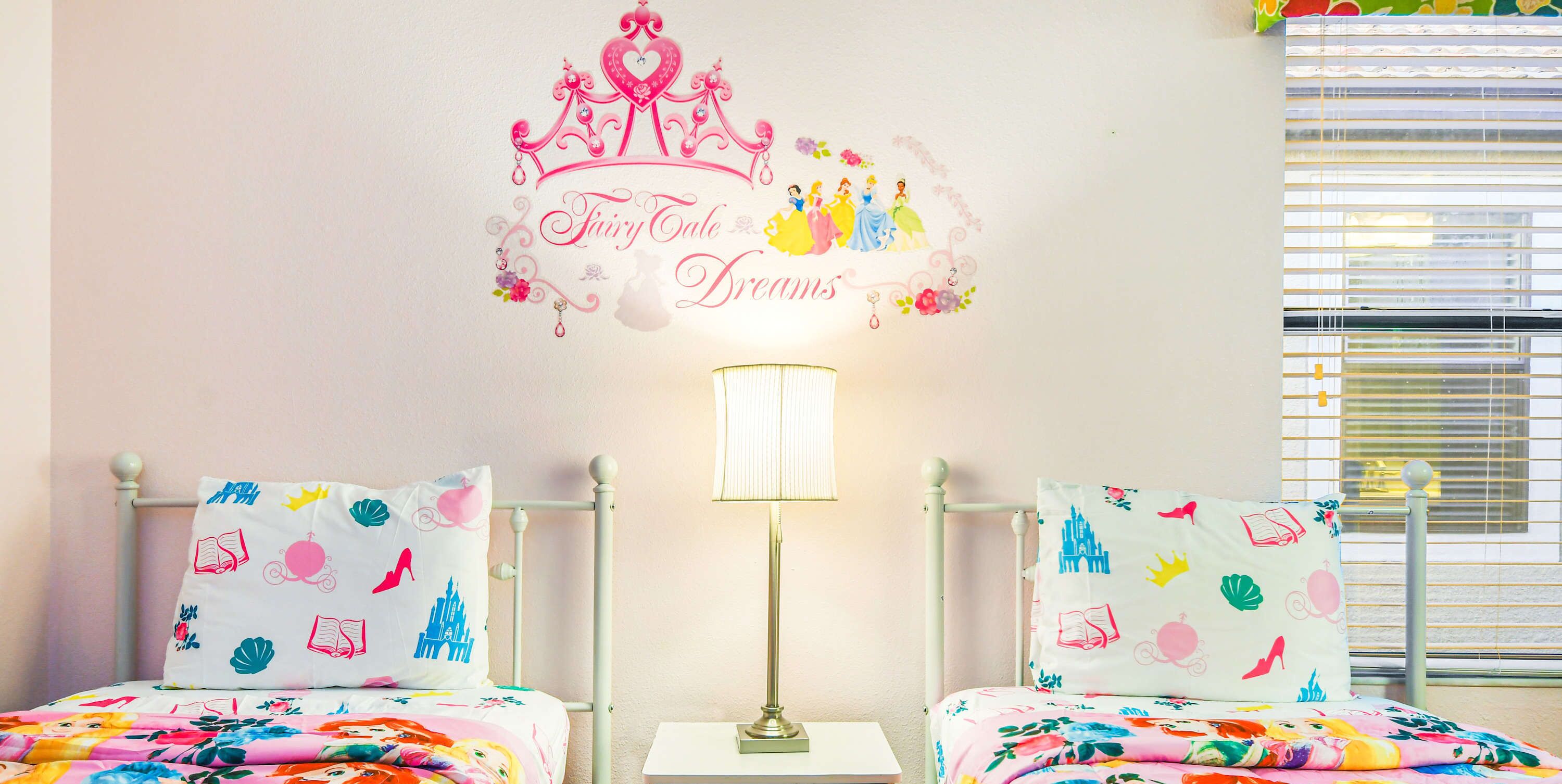Une chambre avec deux lits, une table de chevet, une lampe et un motif décoratif sur le mur.