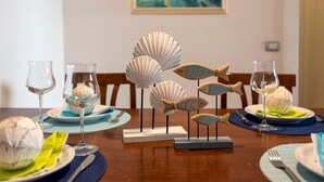 A dining table set with plates, glasses, and decorative fish sculptures. - Borgo 66 in Alghero With 2 Bedrooms and 2 Bathrooms (Alghero)