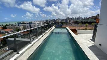 Alberca al aire libre, sombrillas en la alberca y camastros