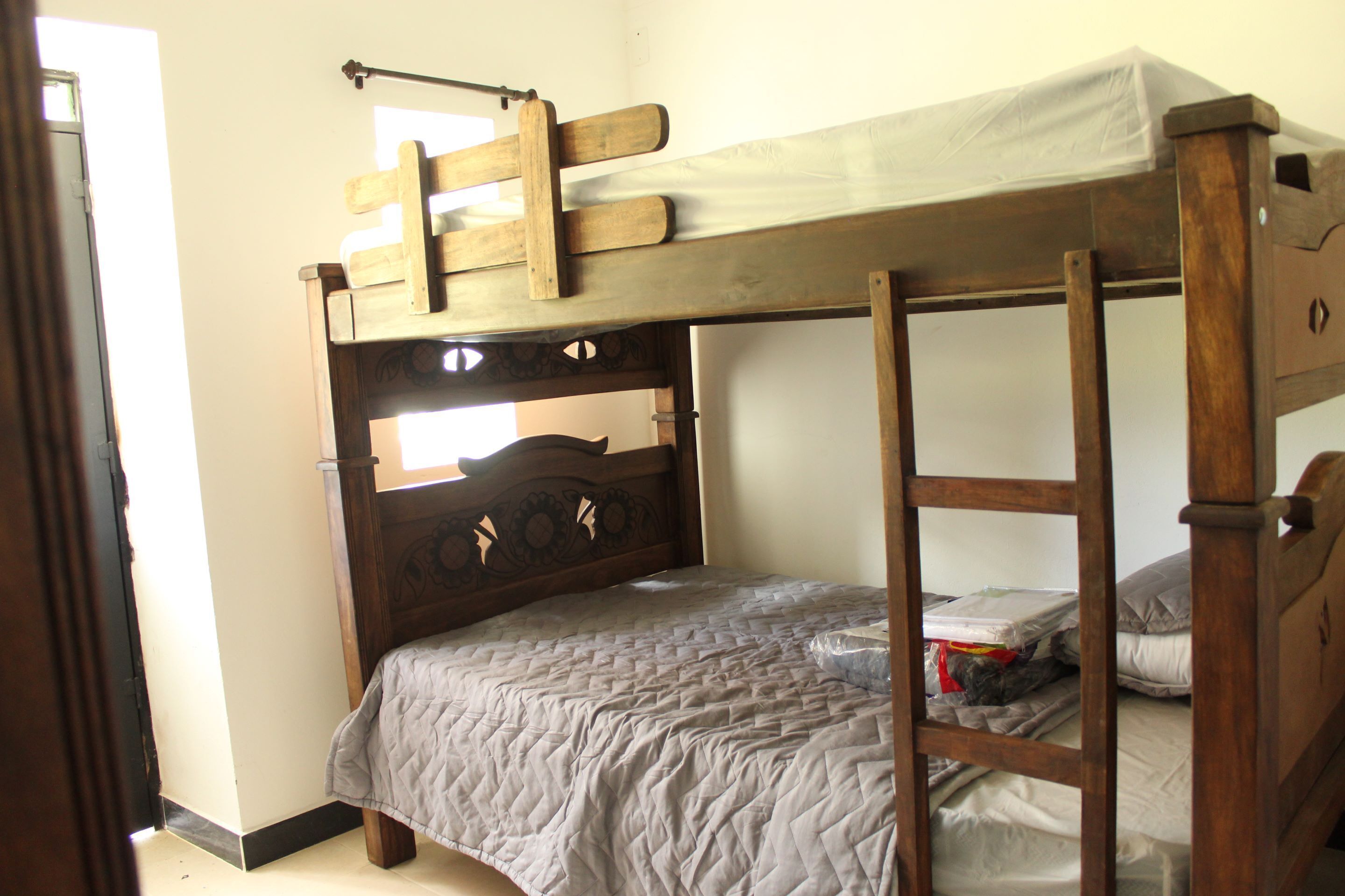 A bunk bed with a wooden headboard and a ladder.