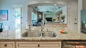A kitchen with granite countertops, double sinks, and a built-in oven. - Resort-Style Oasis with Private Pool (Goodyear)