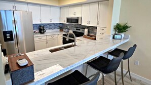 A modern kitchen with a marble countertop, stainless steel appliances, and a built-in microwave. - The fish are biting!!🎣🌞 There is something for everyone! (Orange Beach)