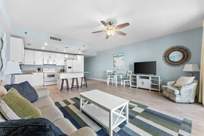 A modern apartment with a kitchen, dining area, and living room.
