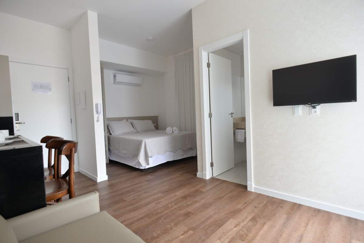 Een slaapkamer met een bed, een bureau en een televisie.