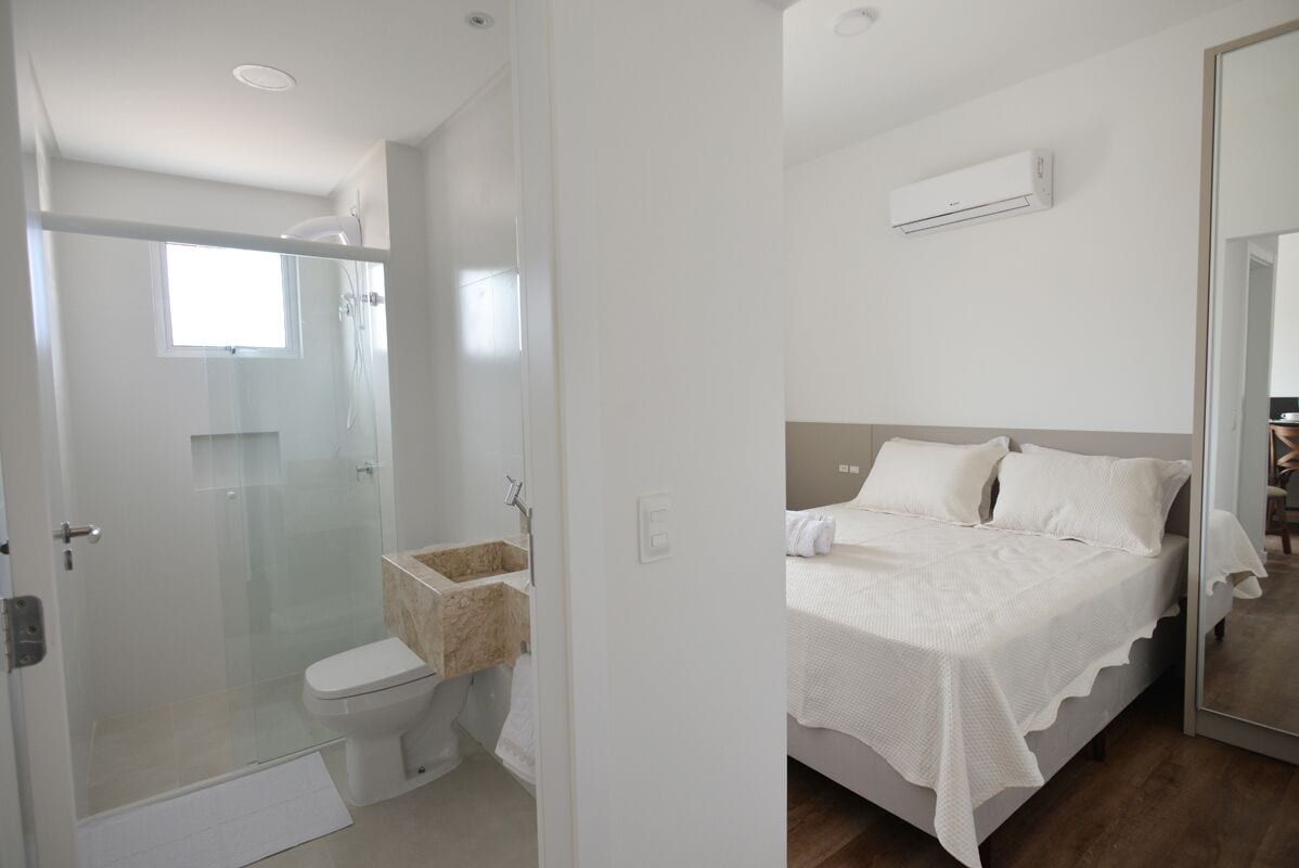 A modern bathroom with a glass-enclosed shower, a toilet, and a sink.