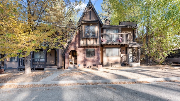 A two-story house with a balcony, a garage, and a driveway. - Snow Summit Getaway - 2-bedroom in Big Bear Lake, Walk to Slopes, Cable TV, Deck, BBQ, Views (Big Bear Lake)