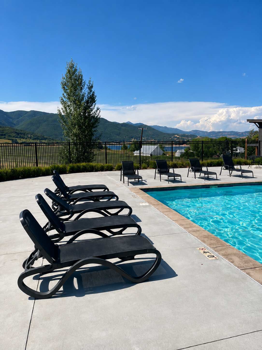 Ein Poolbereich mit Liegestühlen und Bergblick.