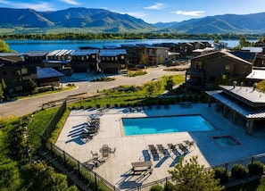 A resort with a swimming pool, lounge chairs, and a view of mountains. - Powder Mountain Escape • Ski-Inspired (Huntsville)