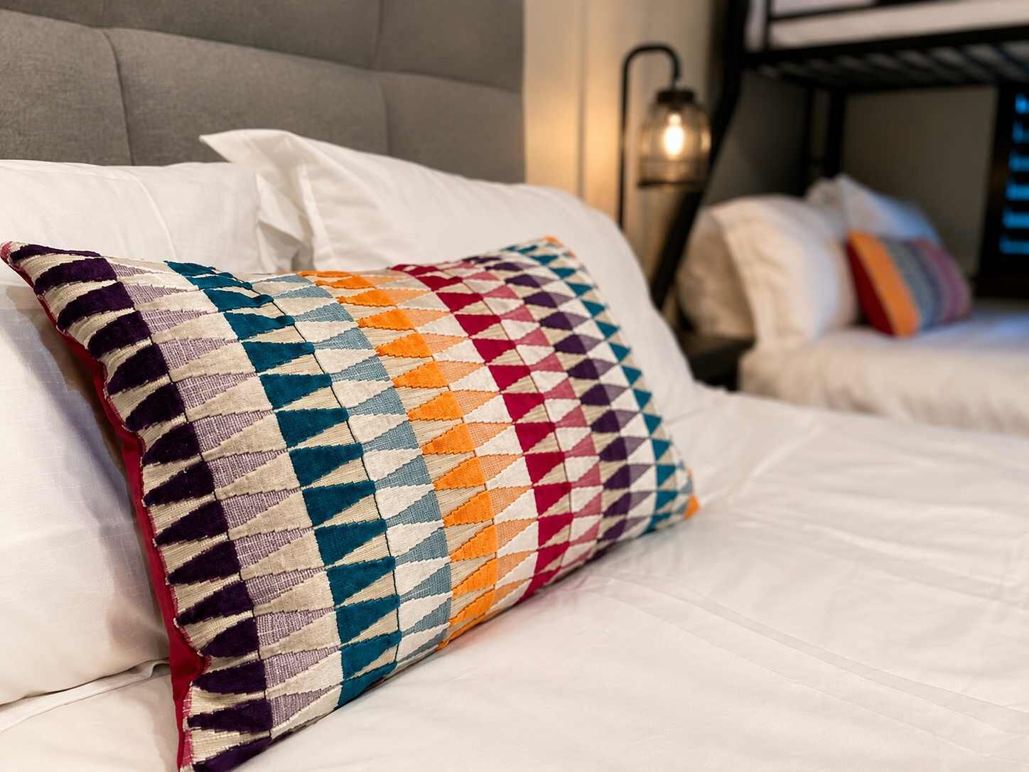 A bed with a patterned pillow and a headboard.
