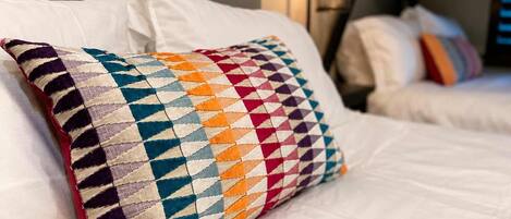 A bed with a patterned pillow and a headboard.