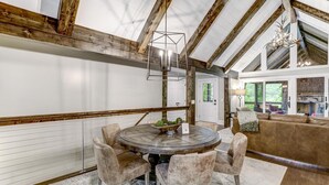 Uma área de refeições com uma mesa redonda, quatro cadeiras e um lustre.