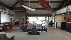 A spacious indoor area with a dining table, sofas, and a hanging red umbrella.