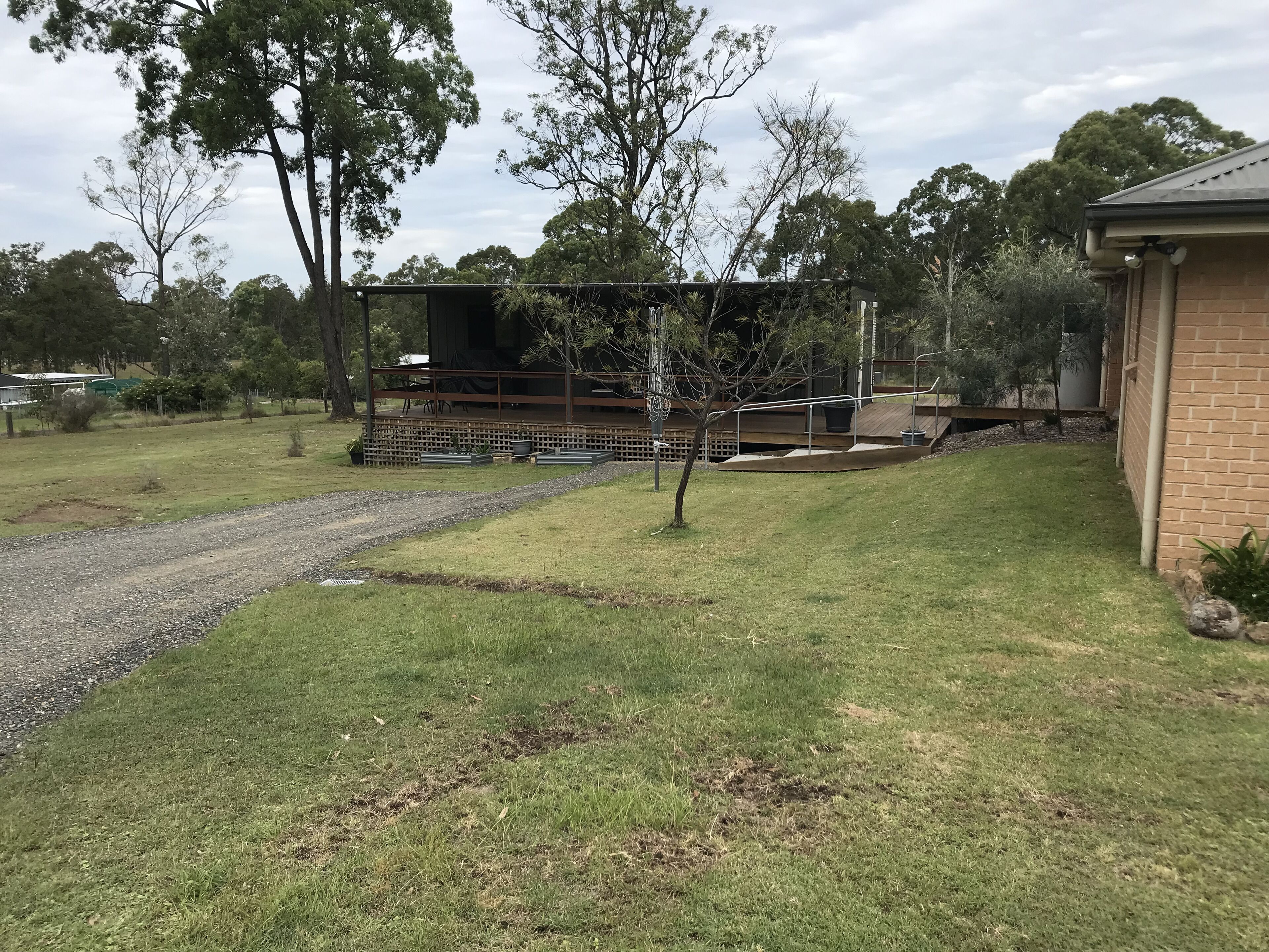 A residential area with a house, a fenced garden, and a gravel path.