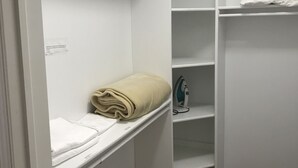A walk-in closet with white shelves, a hanging rod, and a folded beige blanket. - Stylish 1BR unit in Bedford, only 15 min to downtown Halifax. Near shopping area (Halifax)