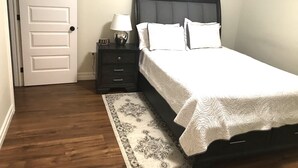 A bedroom with a bed, nightstand, lamp, and a rug. - Stylish 1BR unit in Bedford, only 15 min to downtown Halifax. Near shopping area (Halifax)