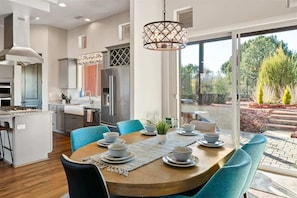 Una cocina moderna con comedor, ventanas amplias y vistas al exterior.