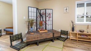 A traditional Japanese-style room with tatami flooring, a low wooden table, and a shoji screen. - Far East Escape: Zen apartment, Japanese tea table (Salem)