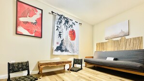A living room with a sofa, two chairs, a wooden bench, and artwork on the walls. - Far East Escape: Zen apartment, Japanese tea table (Salem)