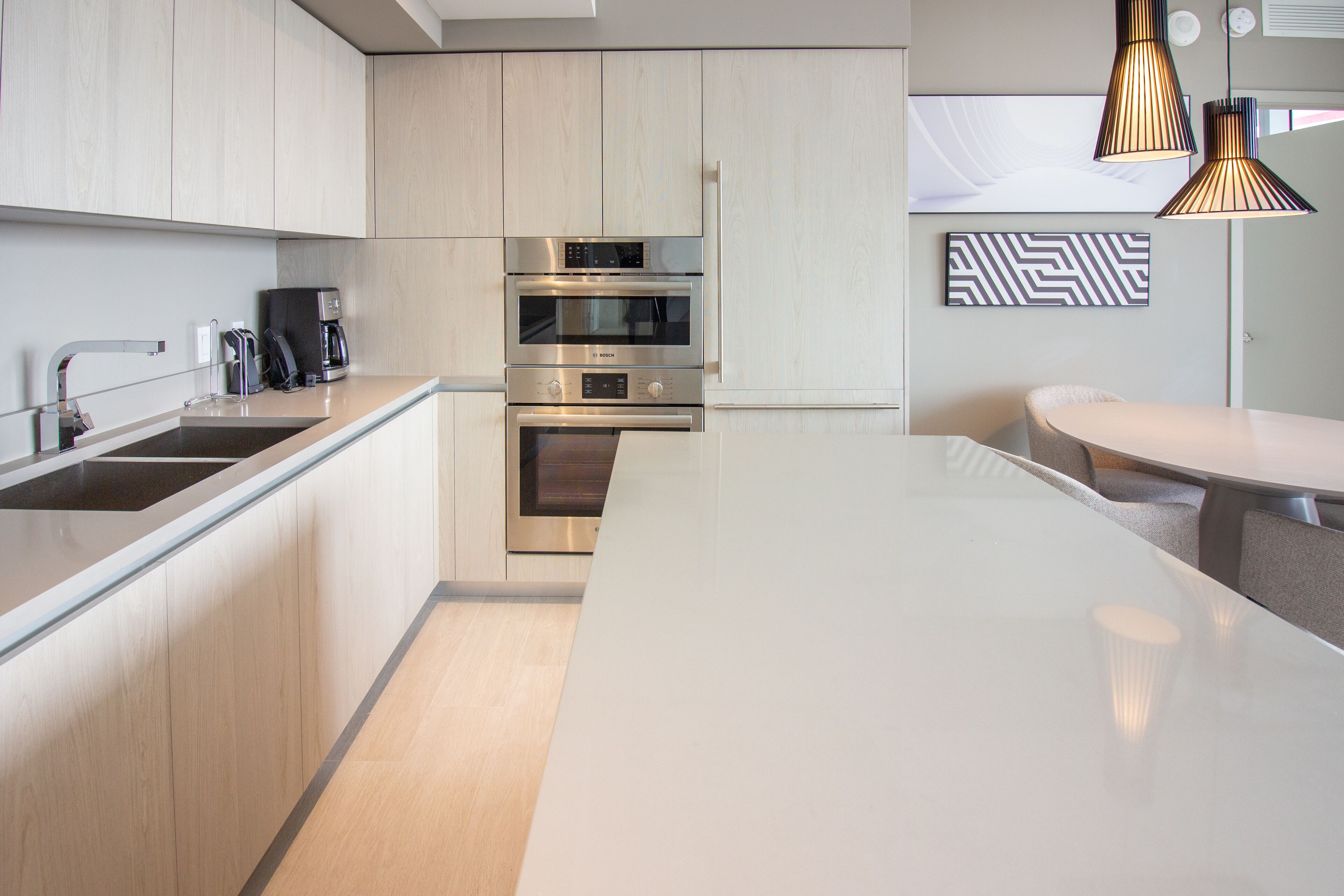 A modern kitchen with stainless steel appliances, a built-in oven, and a large island.