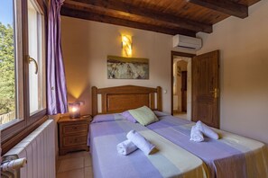 A bedroom with a wooden headboard, a bedside table with a lamp, a rolled towel on the bed, and a window with curtains. - 6 bedroom finca with pool and barbecue (Selva)