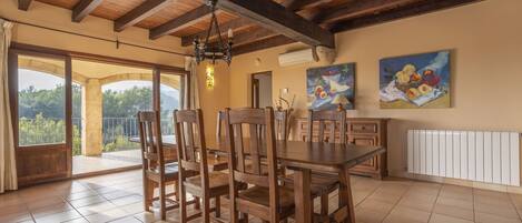 Un comedor con muebles de madera, una araña y obras de arte en las paredes.