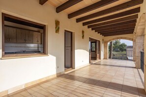 A spacious corridor with tiled flooring, wooden beams, and a view of the outdoors. - 6 bedroom finca with pool and barbecue (Selva)