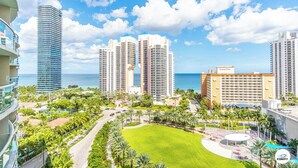 A high-rise hotel complex with multiple buildings, a central green lawn, and a view of the ocean. - Komffy Apartment w/2 Queen Beds and panoramic view (Sunny Isles Beach)