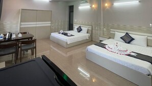 Una habitación de hotel moderna con comedor, dos camas y un escritorio.