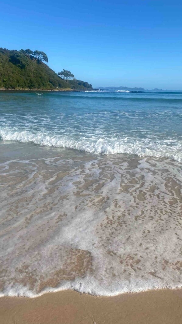 Enjoy a serene beach experience with gentle waves lapping onto the shore.