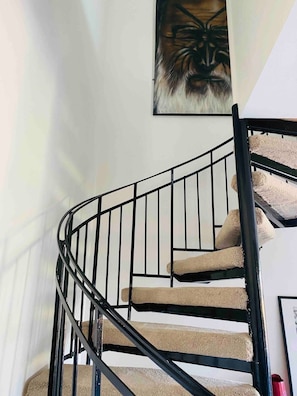 Staircase with carpeted steps and a framed artwork above.