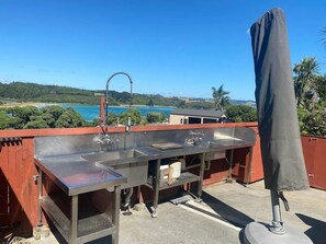 Enjoy panoramic views of the surrounding landscape from our rooftop bar, featuring a clear view of the body of water and distant hills.